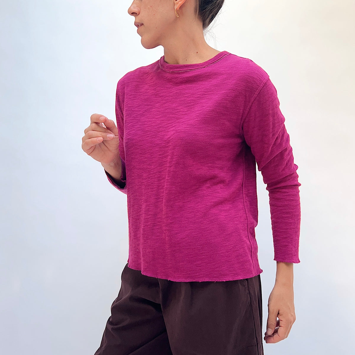 North Star Base Double Cotton Tee in Beet, side view showing the slightly cropped sleeve and raw-edge hem detail in beet pink