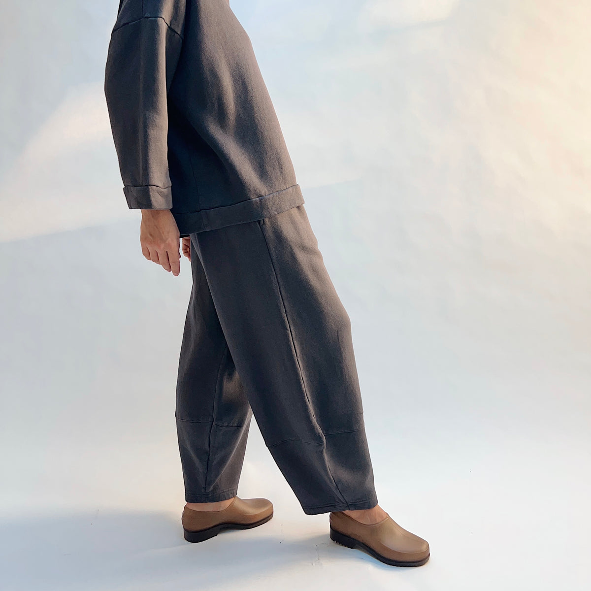 Side view of Oliver Fleece Pant in Moonlight on a model, showing the curved silhouette and lower-leg seam detail.
