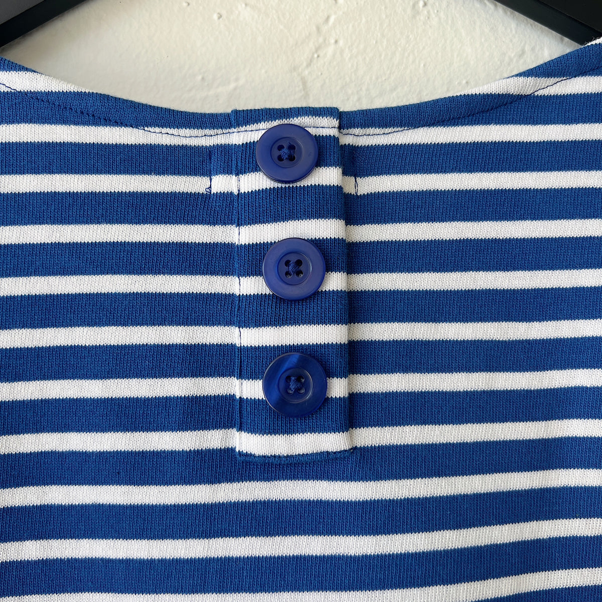 Close-up of a blue and white striped garment with buttons.