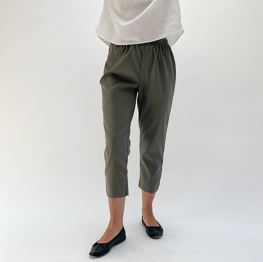 Close front view of model wearing Cut Loose kelp taper crop pant, showing elastic waist, relaxed hip fit, and tapered leg narrowing at the ankle