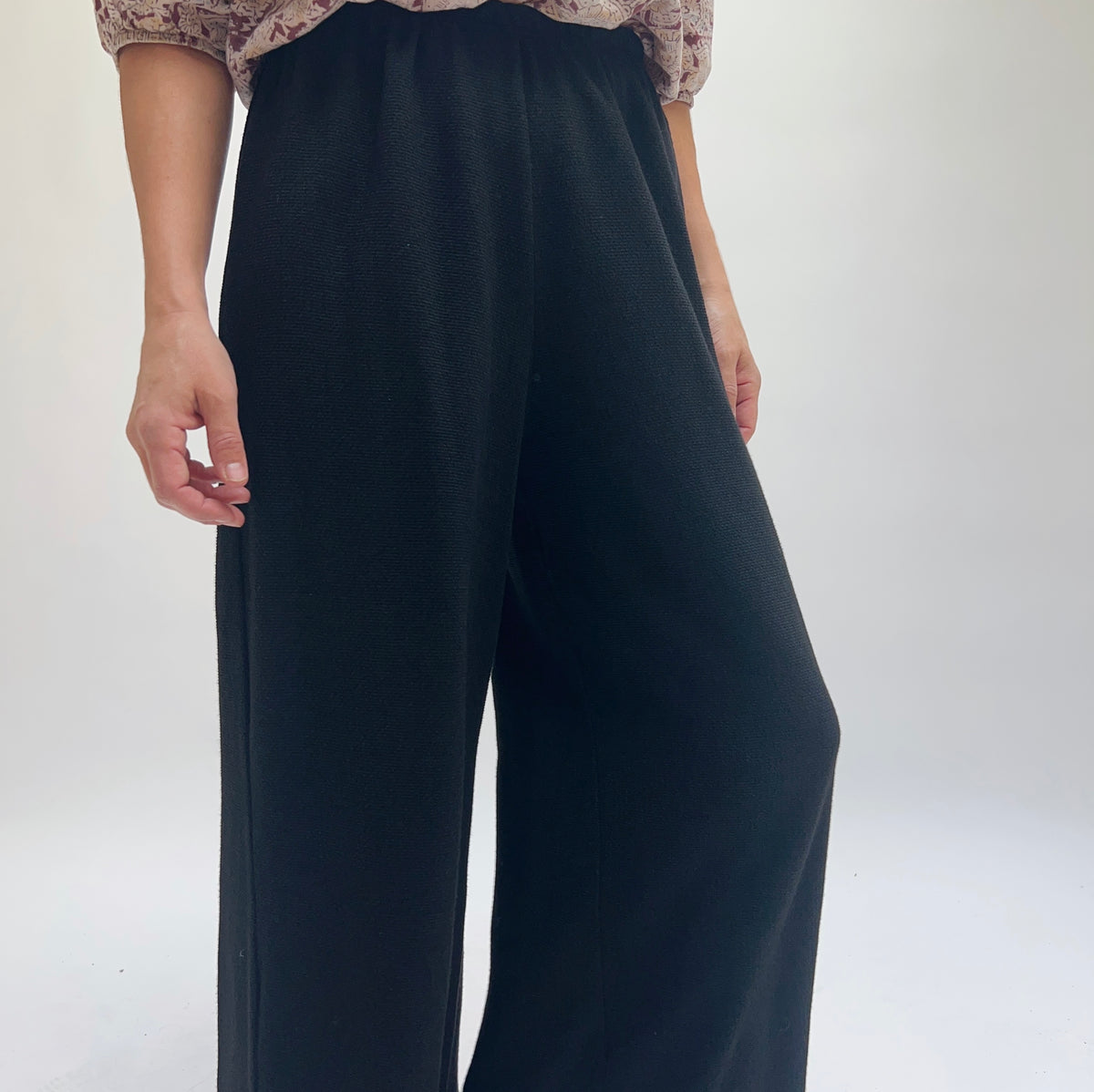 Close-up of Cut Loose Marled Knit Crop Pant in Black showing elastic waistband detail and marled knit fabric texture