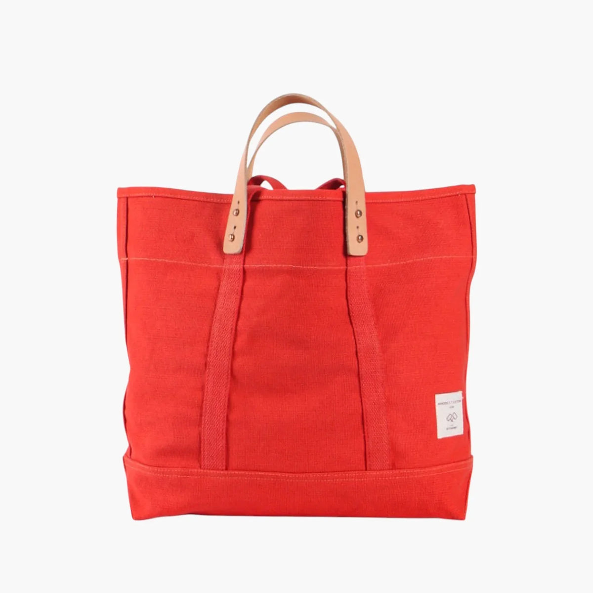 Immodest Cotton Small East West Tote in Persimmon red-orange canvas with natural leather handles.