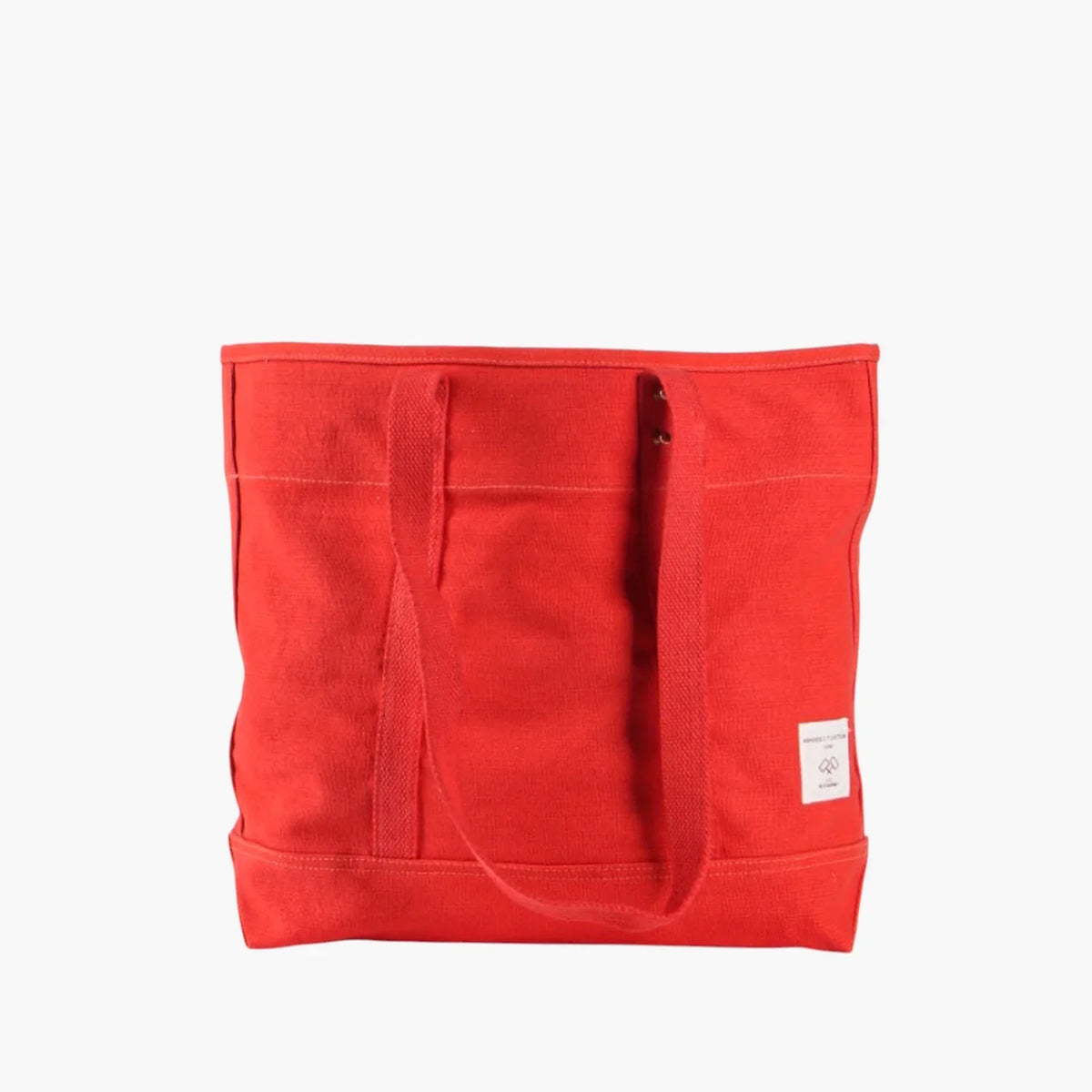 Persimmon red-orange canvas tote with long matching webbing shoulder straps and a white brand label.
