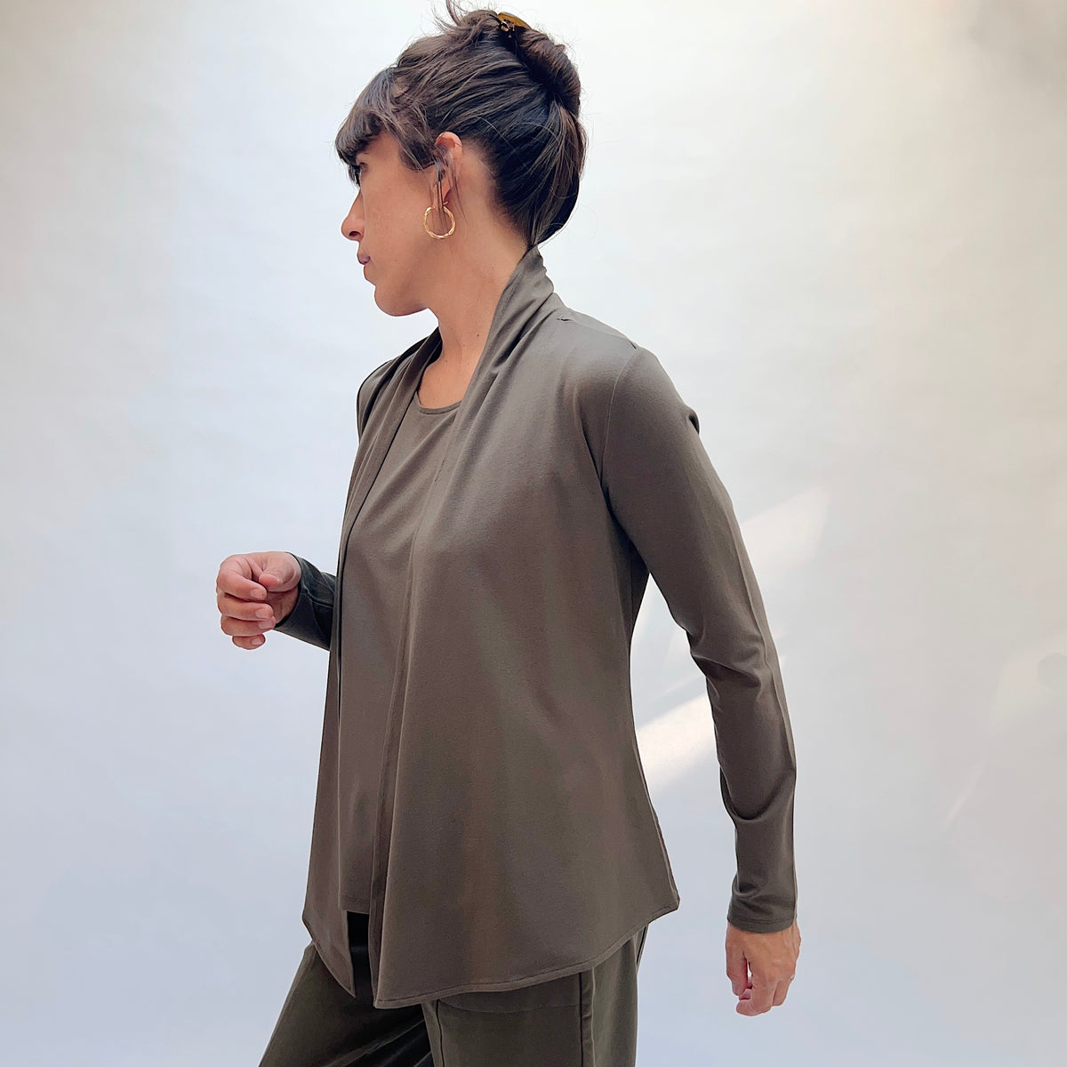 Habitat Core Travel Waterfall Jacket in Umber, side view showing the hip-length silhouette and draped waterfall front panels
