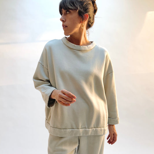 Front view of Bryn Walker Alden Fleece Sweatshirt in Orlaya on a model, showing the draped neckline, dropped shoulders, and banded hem.
