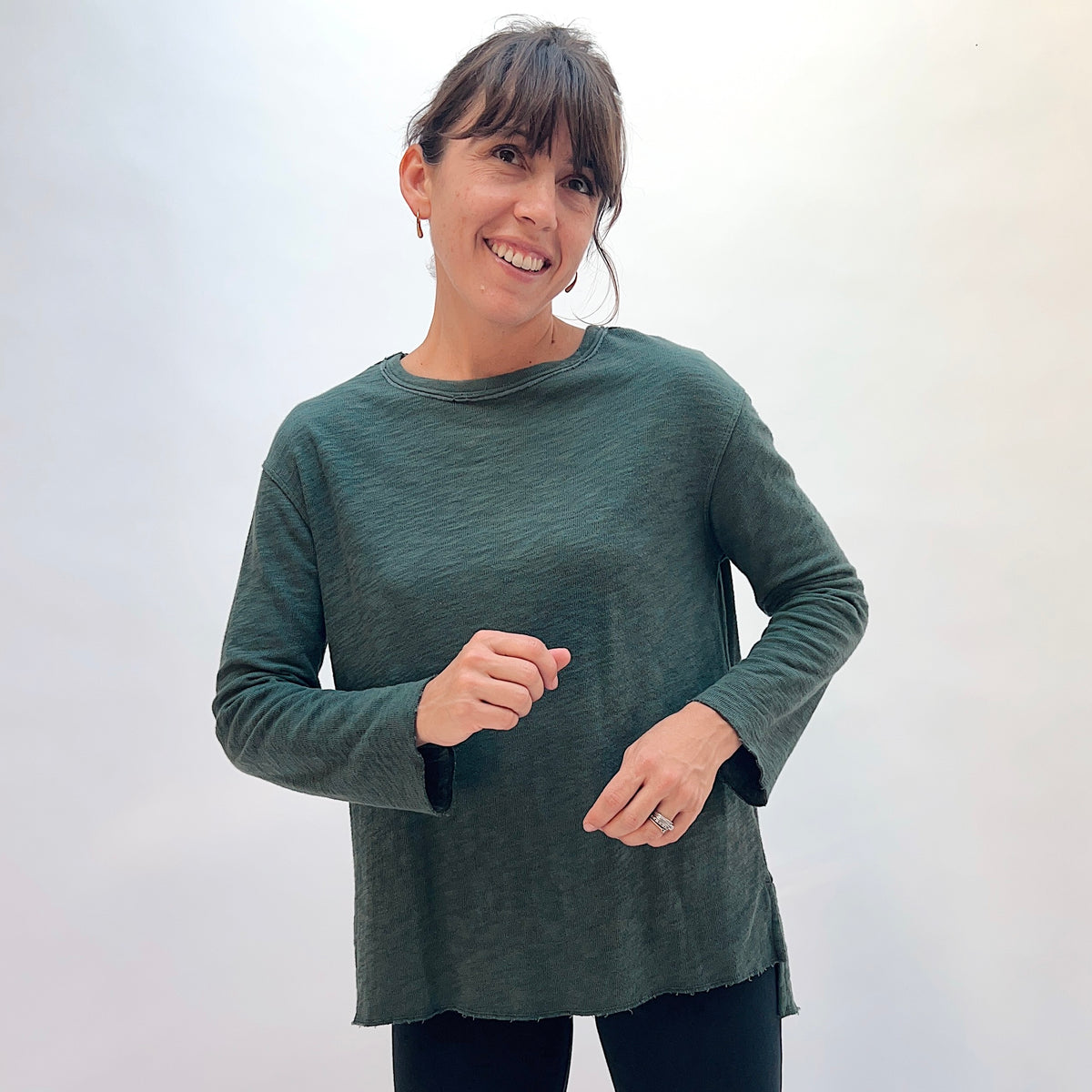 North Star Base Double Cotton Beach Tee in Konbu, front view showing the crew neck with raw-edge finish and high-low hem in konbu green
