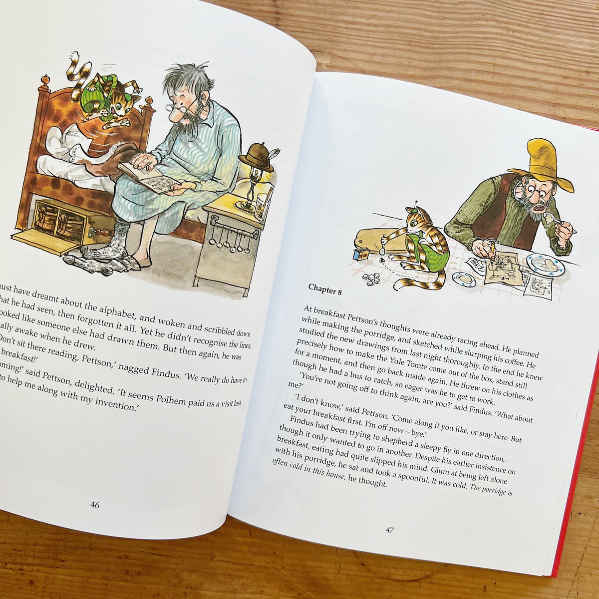 Open pages of Findus and the Christmas Tomte, with illustrations of Pettson reading in bed and sitting at breakfast with Findus.
