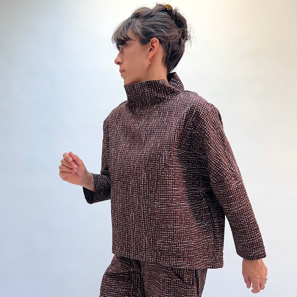 Niche Sofi Top in Cocoa Check, side view showing the relaxed boxy silhouette and high funnel neck in dark brown textured check with contrast black cuffs
