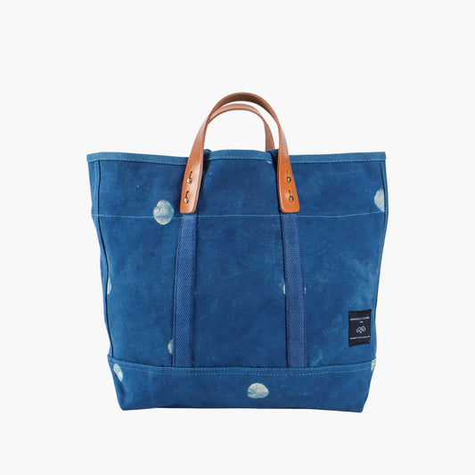 Small Light Indigo Moon tote, front view, with cream moon prints, leather handles, and blue webbing straps.
