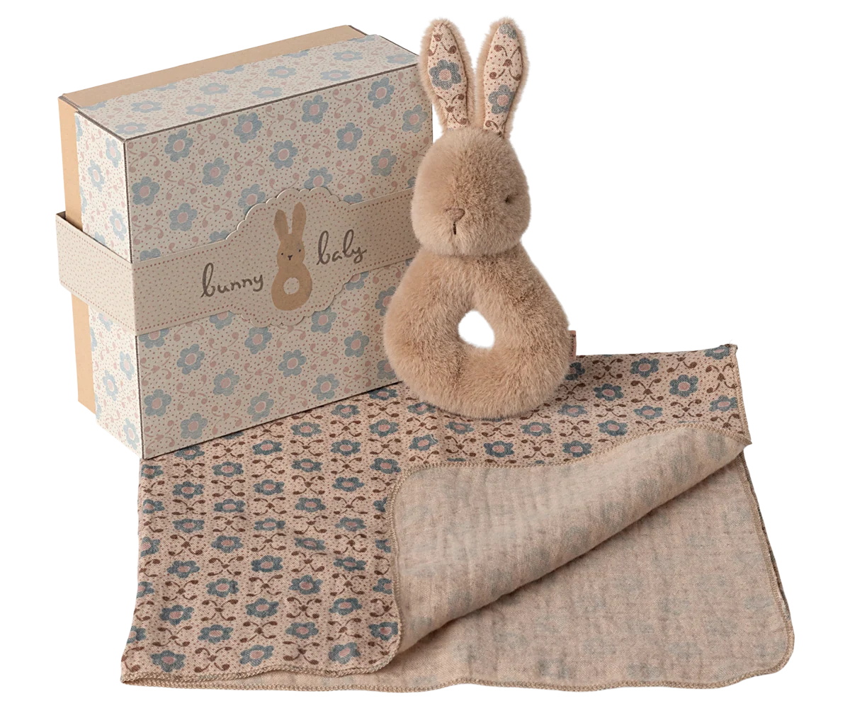 Maileg Rabbit Rattle in Peachy Cream on a white background — a plush peachy-cream bunny ring rattle with a round body, loop handle, and tall floral-lined ears
