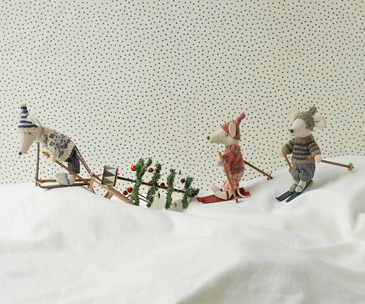 Maileg Winter Mouse Ski Big Brother — lifestyle scene of three Maileg mouse dolls in winter ski outfits on a snowy white surface, with a miniature sled, Christmas tree, and holiday accessories
