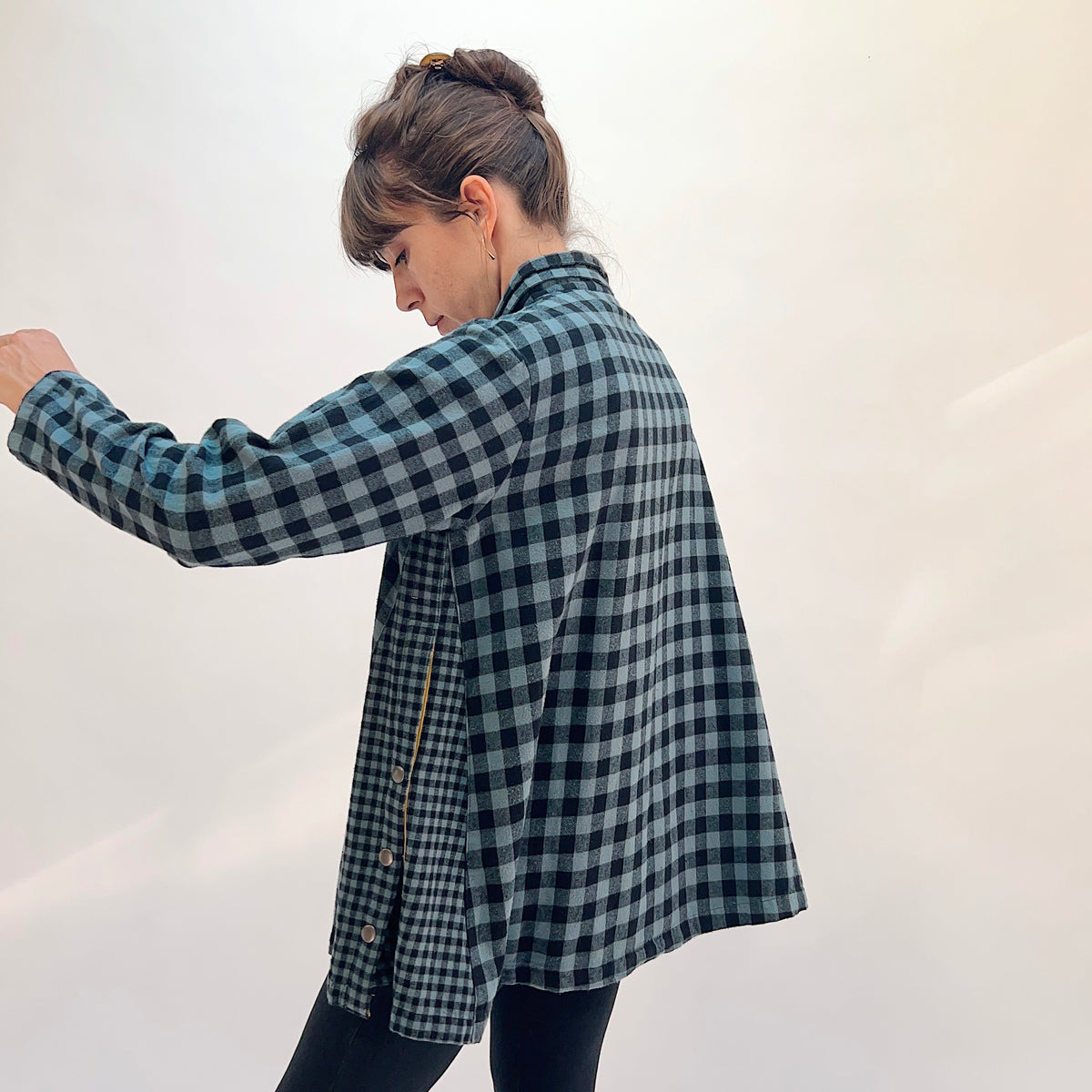 Eleven Stitch Placket Gusset Shirt in Dusty Denim, three-quarter back view showing the side gusset panel with mustard contrast detail and snap buttons in dusty blue and black gingham check cotton
