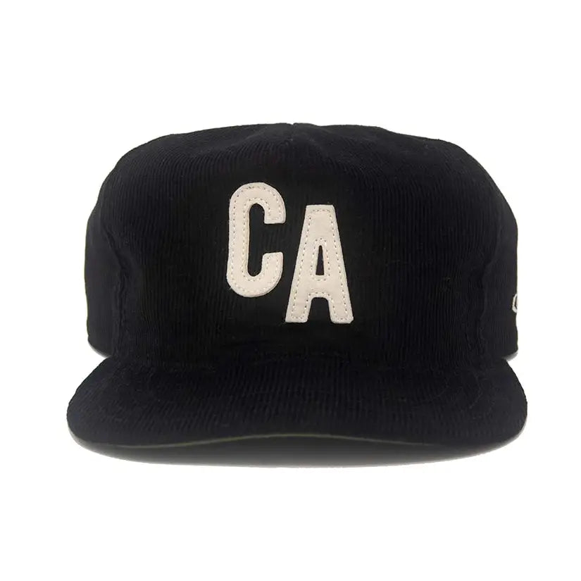 Front view of the Ampal Creative CA Snapback in black 14-wale corduroy, featuring a cream vintage felt CA appliqué on the front panel and an unstructured crushable crown with flat brim, on a white background
