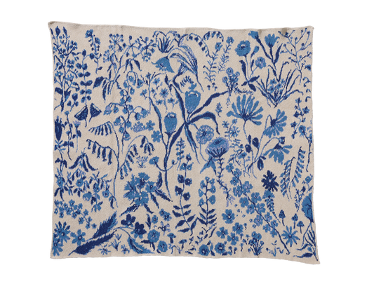 Flower Field Sky Blue child blanket laid flat, with light blue and navy flowers, leaves, and stems on cream.
