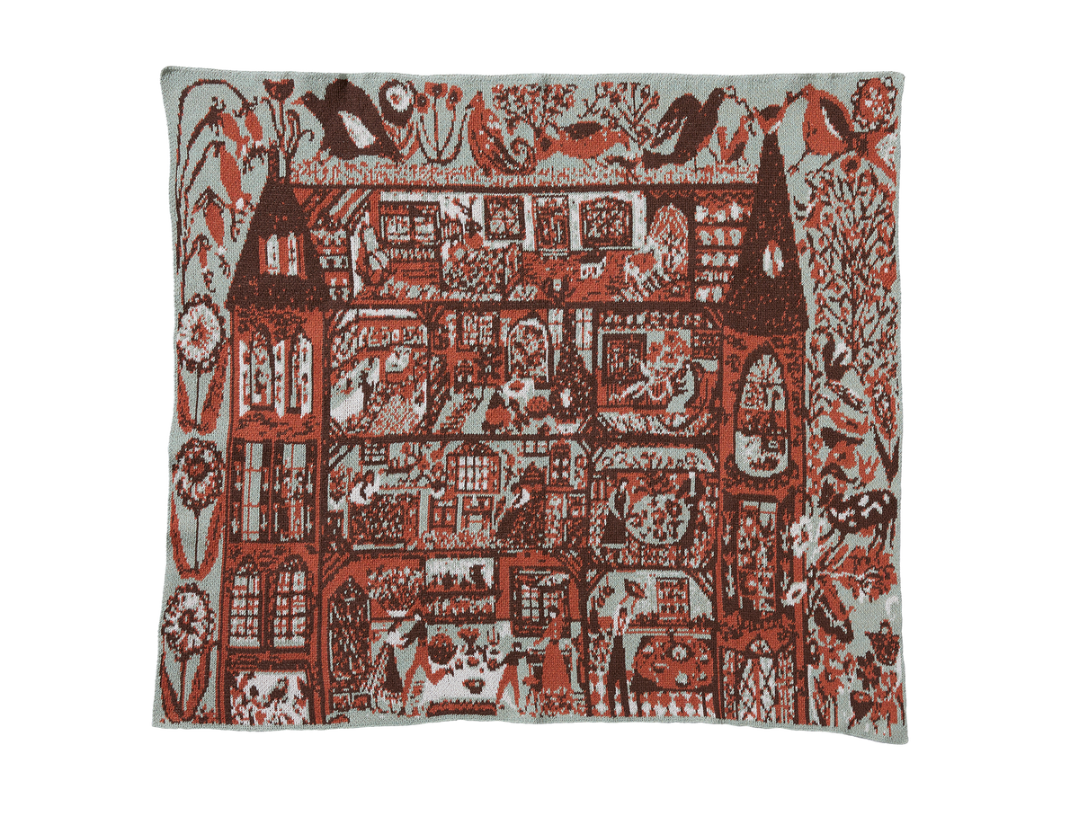 Swedish Farmhouse Sky Green child blanket laid flat, showing red and brown farmhouse rooms, birds, and flowers on pale green.
