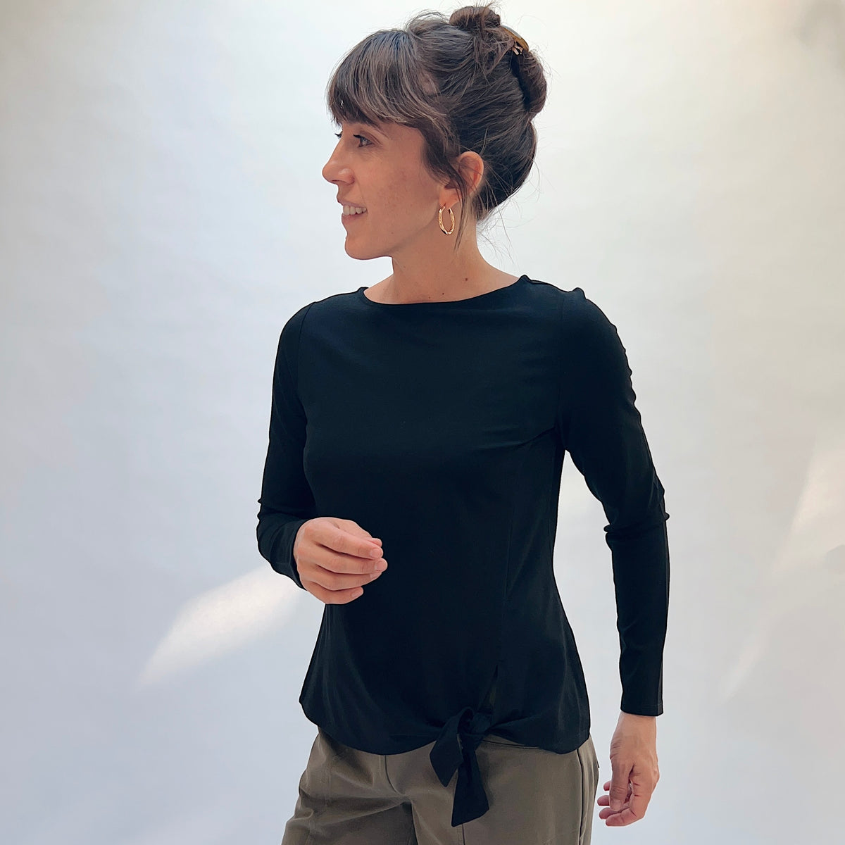 Habitat Core Travel Tie Front Top in Black, front three-quarter view showing the bateau neckline and tie-front hem detail
