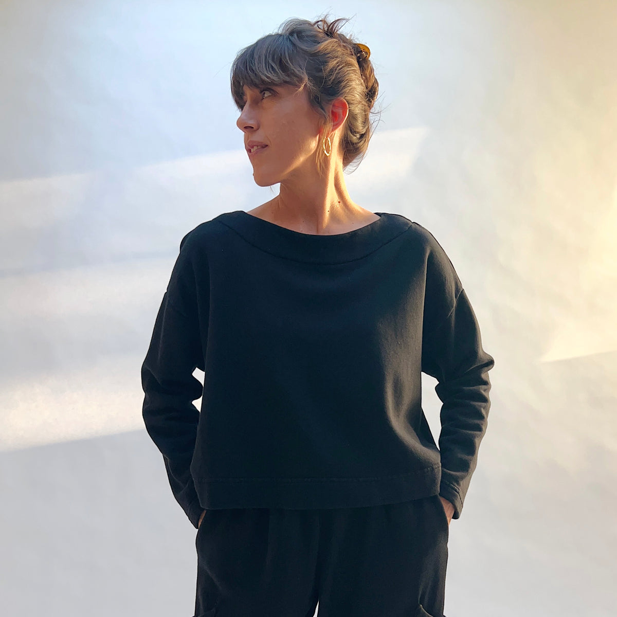 Front view of Bryn Walker Button Back Fleece Pullover in Black on a model, showing the wide neckline and dropped shoulders.

