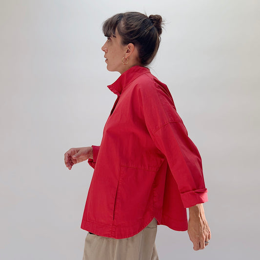 Eleven Stitch Stand Collar Jacket in Cayenne, side view on model, cayenne red cotton with stand collar and rolled cuffs, paired with khaki wide-leg trousers
