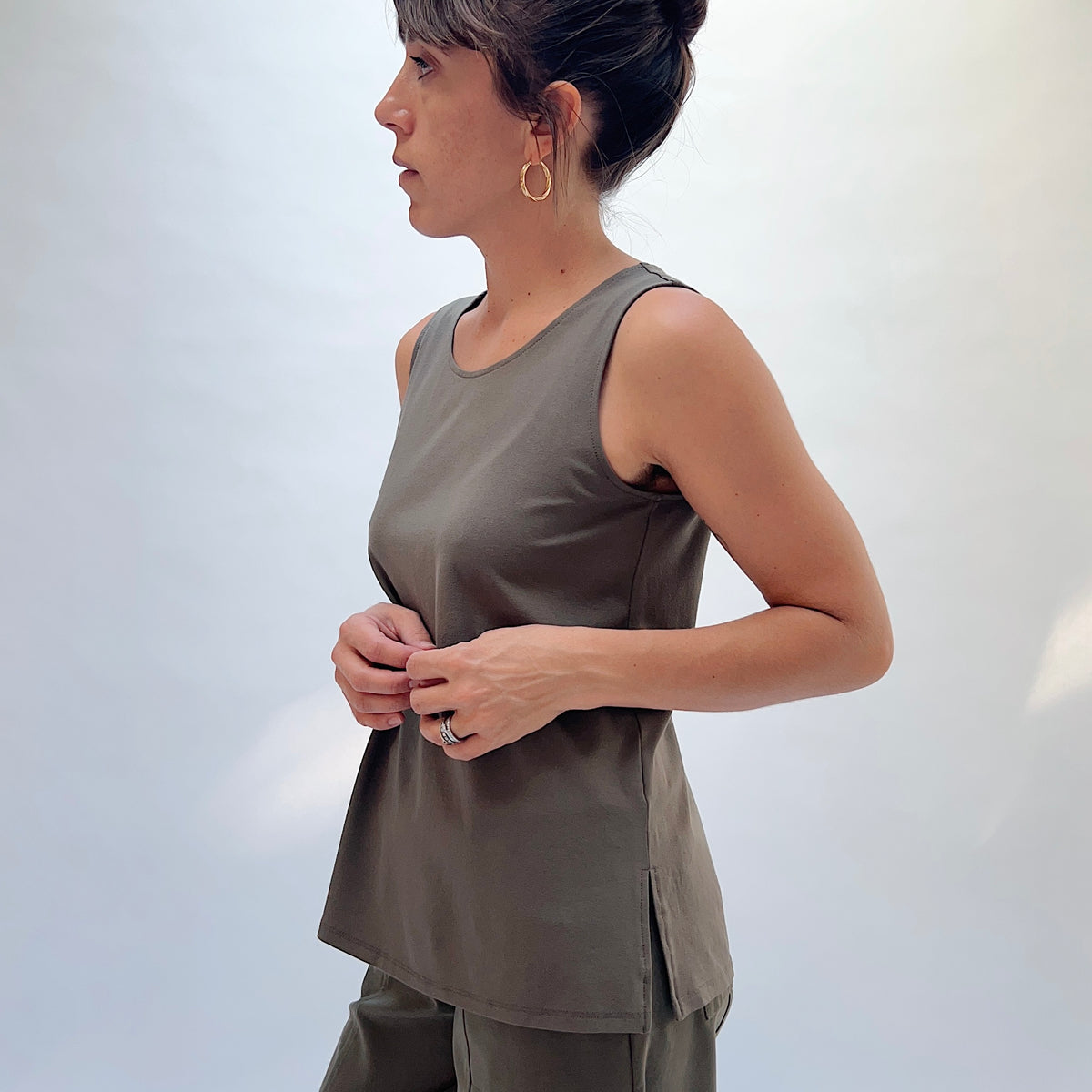 Habitat Core Travel Easy Tank in Umber, side view showing the scoop neckline, relaxed fit, and side slit hem detail
