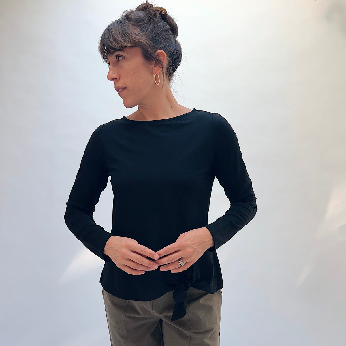 Habitat Core Travel Tie Front Top in Black, front view showing the fitted silhouette, bateau neckline, and tie-front hem
