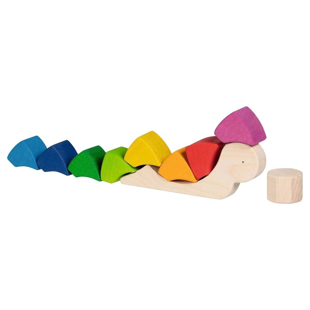 Goki Sassy Snail Puzzle disassembled on a white background, with the natural wood snail body laid flat and all 9 rainbow-colored wedge blocks spread out in a row from blue through green, lime, yellow, orange, red, and pink, with the natural wood cylinder center piece placed separately to the right