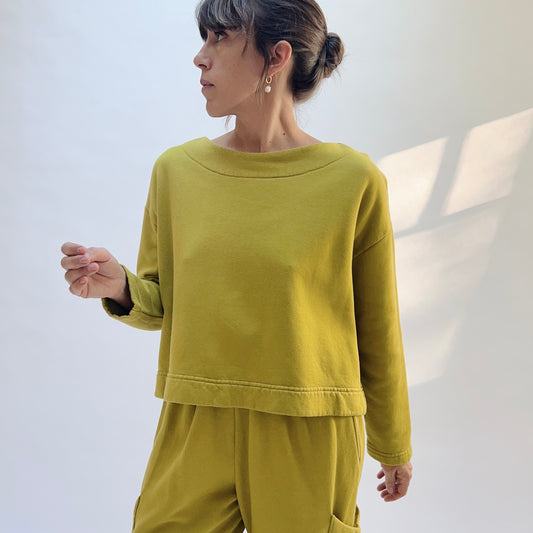 Front view of Bryn Walker Button Back Fleece Pullover in Chartreuse on a model, showing the wide neckline and dropped shoulders.
