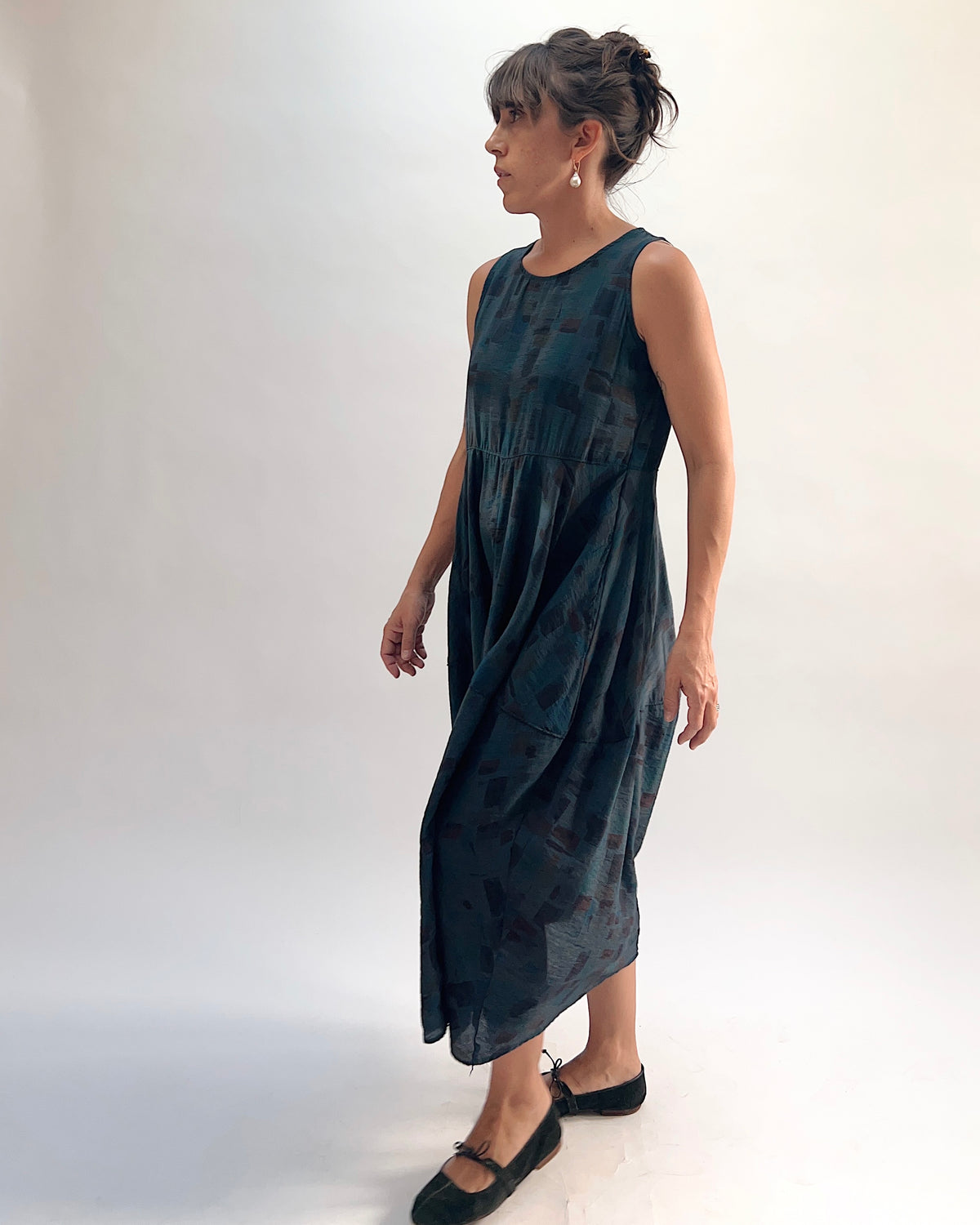 Model wearing the Cut Loose Sea Glass Seamed Parachute Bubble Dress in Etan — a deep teal semi-sheer viscose-nylon with an abstract brushstroke block print and voluminous bubble skirt silhouette, three-quarter view
