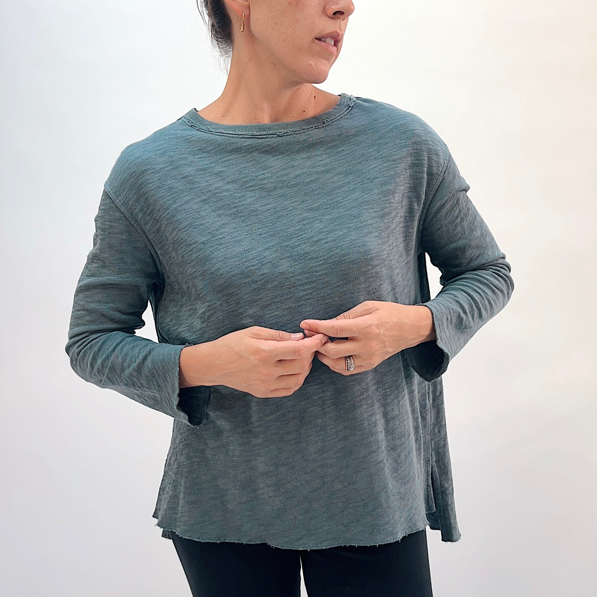 North Star Base Double Cotton Beach Tee in Dusty Denim, close front view showing the exposed raw-edge crew neckline and double-layered fabric texture in dusty teal

