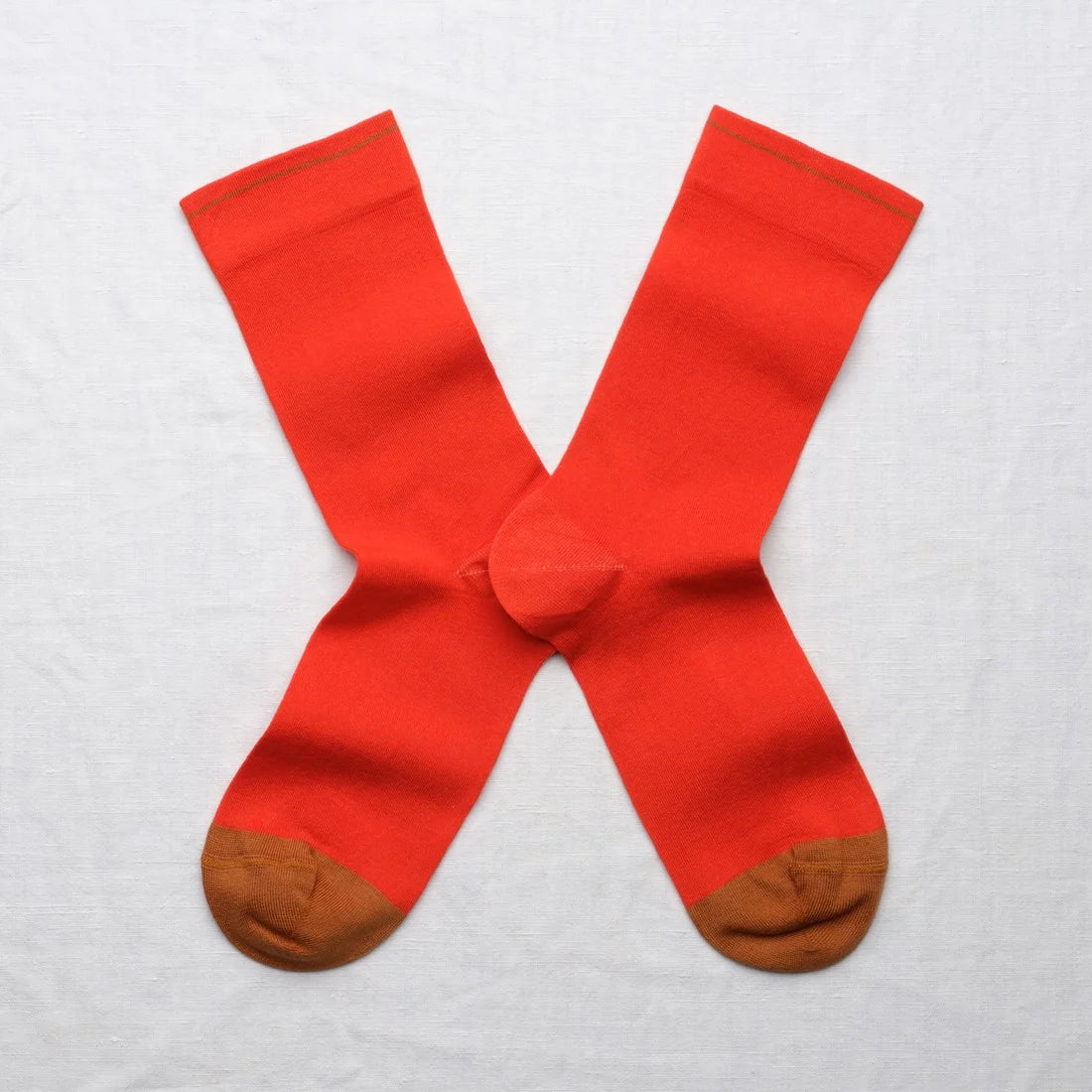 Bonne Maison Solid Vermillion Socks, flat lay pair showing solid vermillion body with contrast caramel toe
