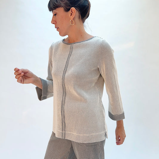 Habitat Opposites Attract Seamed Pullover in Winter White, side view showing the center front seam, 3/4 sleeves with wide contrast cuff, and side slit in grid-textured thermal knit
