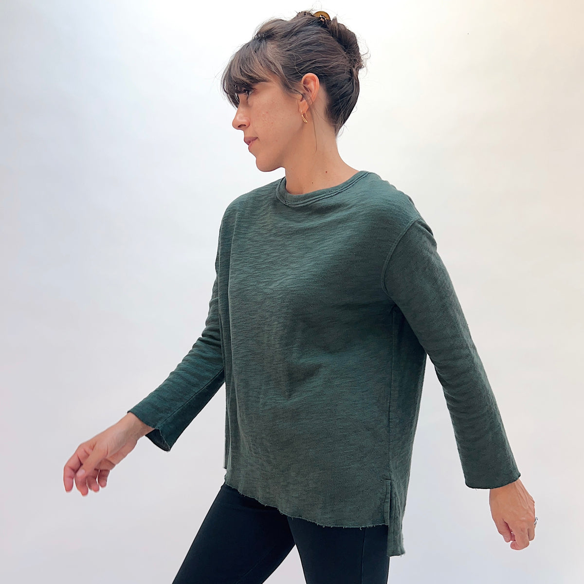 North Star Base Double Cotton Beach Tee in Konbu, side view showing the side slit and high-low hem detail in konbu green
