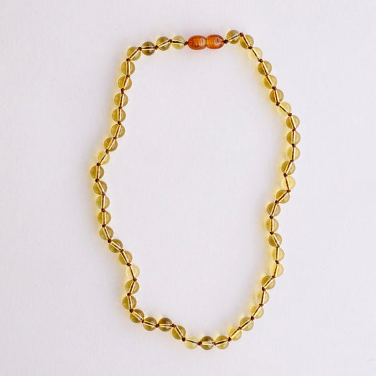 CanyonLeaf Pure Gemstone + Citrine Necklace — a hand-knotted necklace of smooth translucent pale yellow citrine beads with a honey amber screw clasp, laid flat on a white background