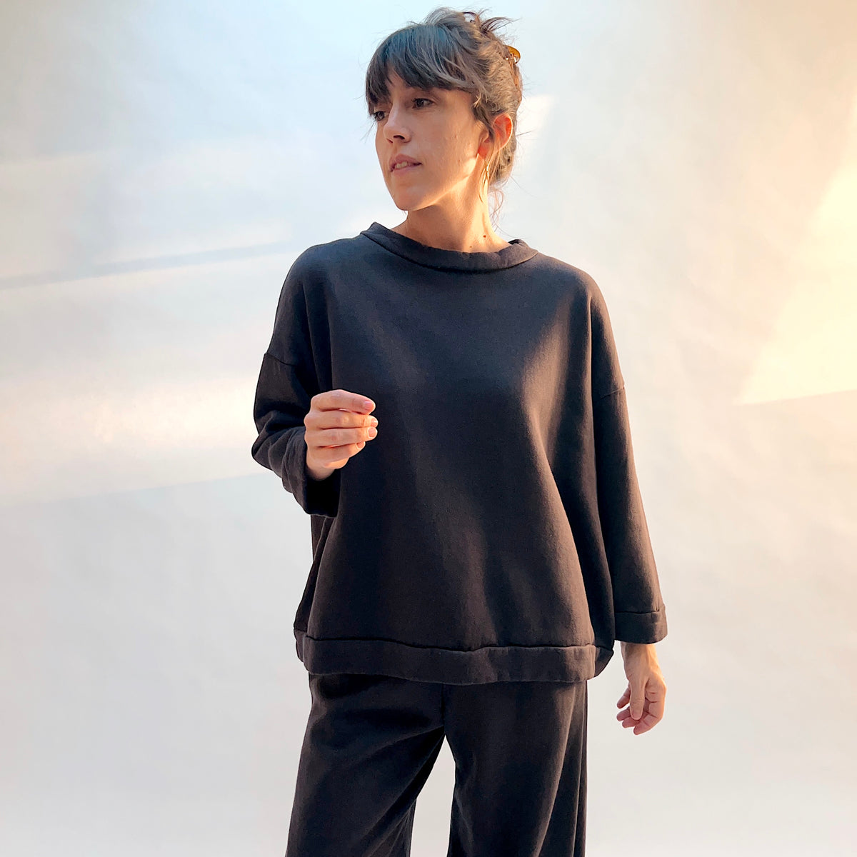 Model wearing Alden Fleece Sweatshirt in Fig, showing the oversized shape and wide sleeves with folded cuffs.
