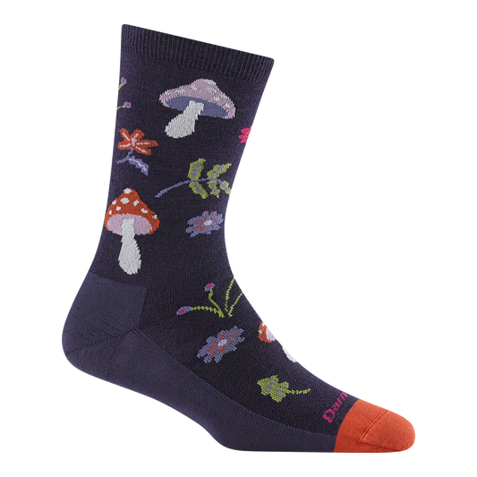 A single crew sock on a plain white background, featuring a dark navy base with a colorful knit pattern of mushrooms, flowers, leaves, and a bright orange toe cap.