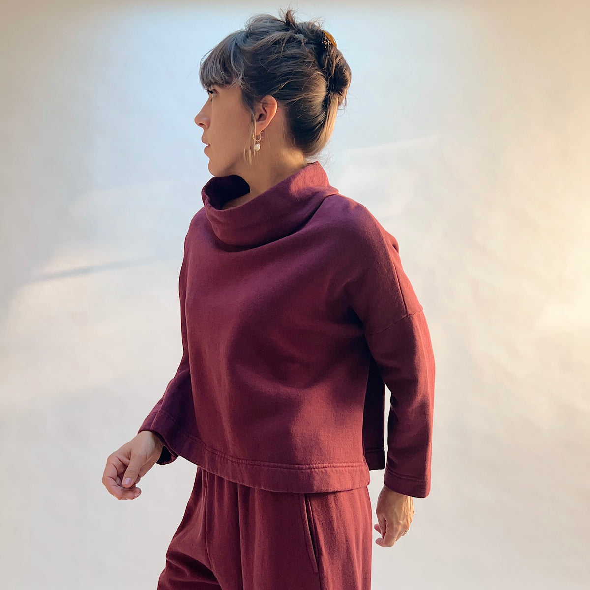 Side view of Cropped Fleece Stowe Sweatshirt in Rhone, showing the dropped shoulders, long sleeves, and short silhouette.
