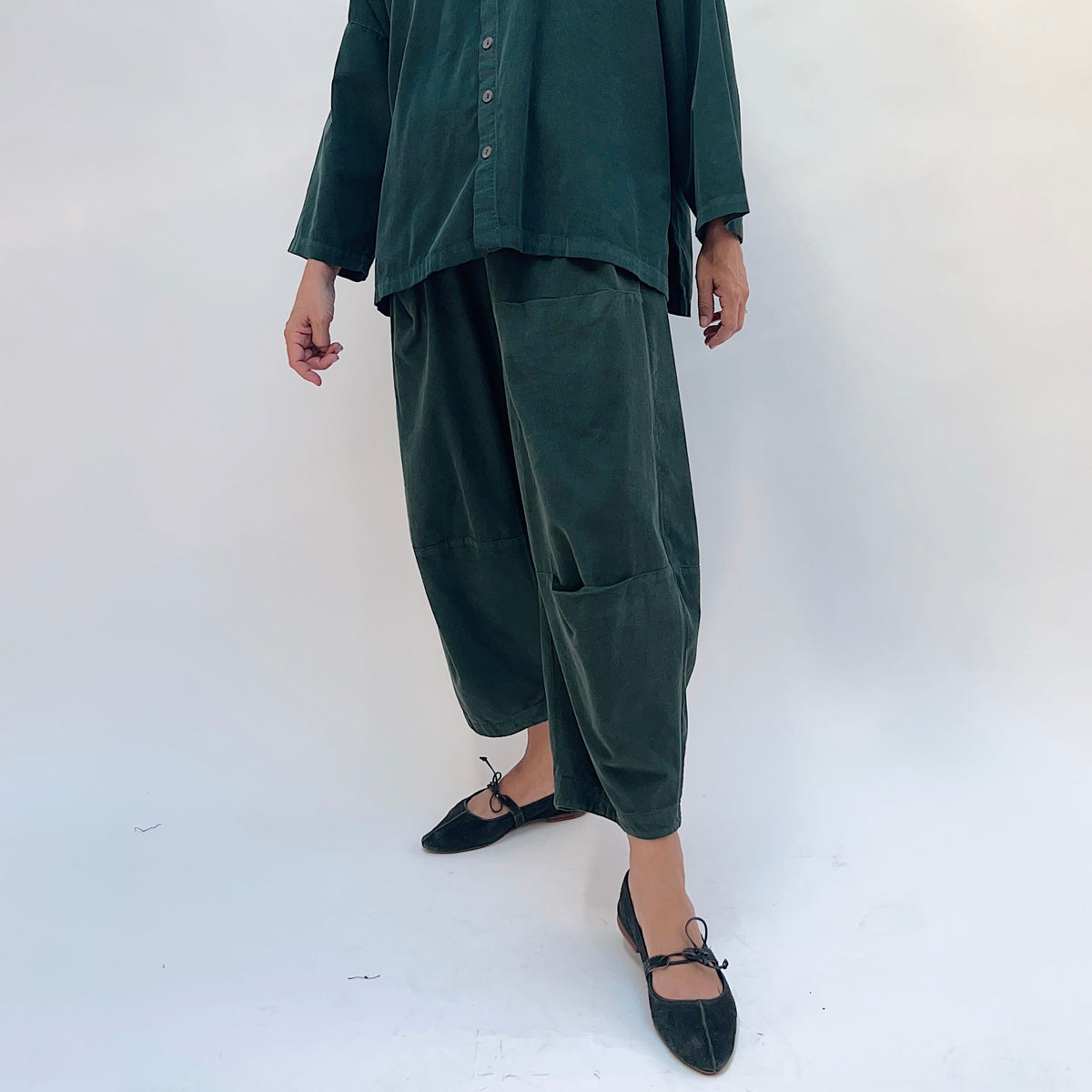 Eleven Stitch Corduroy Three Pocket Pant in Konbu, front three-quarter view showing the patch pocket and tapered crop hem in dark green fine-wale corduroy
