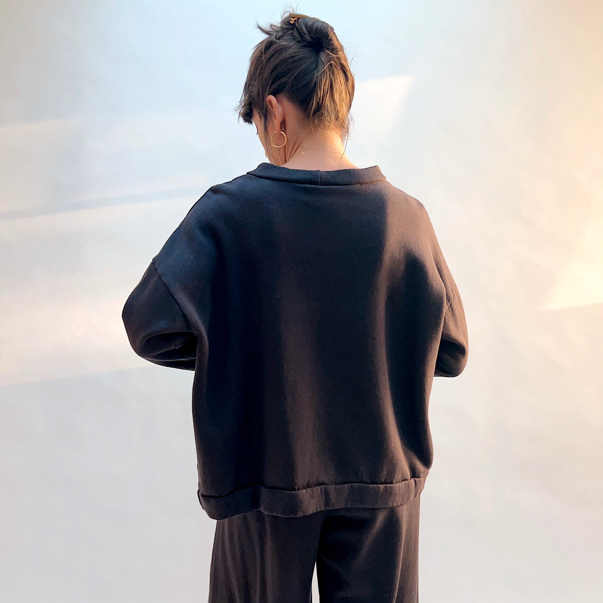 Back view of Alden Fleece Sweatshirt in Fig, showing the wide silhouette, dropped shoulders, and banded hem.

