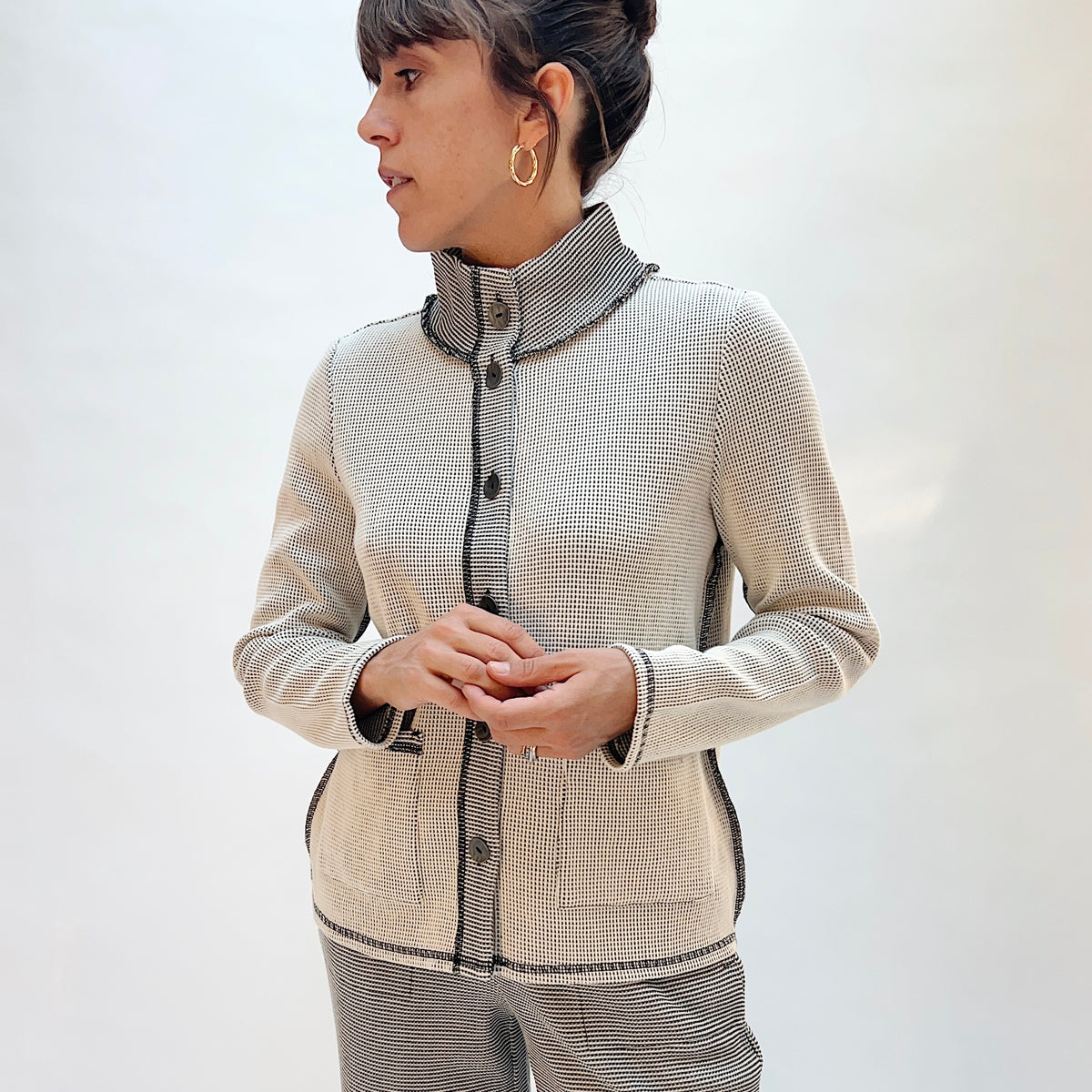 Habitat Opposites Attract Jacket in Winter White, front three-quarter view showing the stand collar, button-front closure, and contrast trim in grid-textured thermal knit
