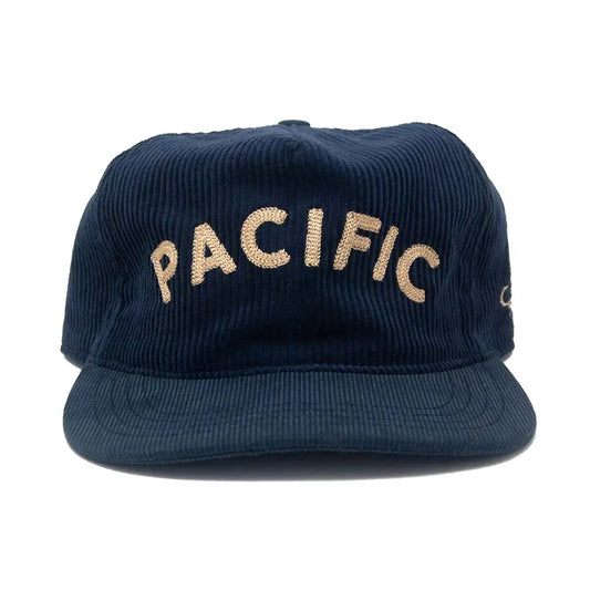 A dark navy blue corduroy baseball cap with 'PACIFIC' embroidered in beige across the front, shown against a plain white background.