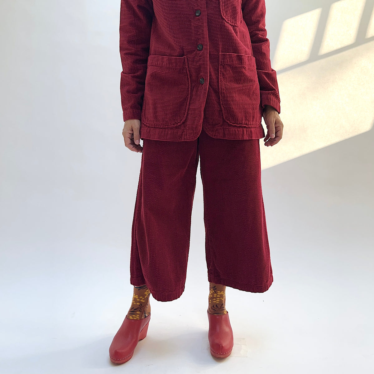Front view of the Lux Corduroy Crop Wide Leg Pant in Maraschino, showing the wide legs and vertical corduroy texture.
