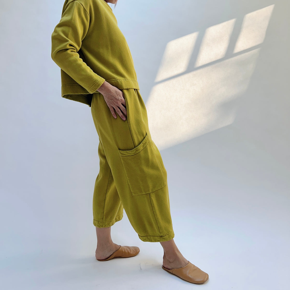 Side view of Pasha Fleece Pant in Chartreuse on a model, showing the side pocket opening and large thigh patch pocket.
