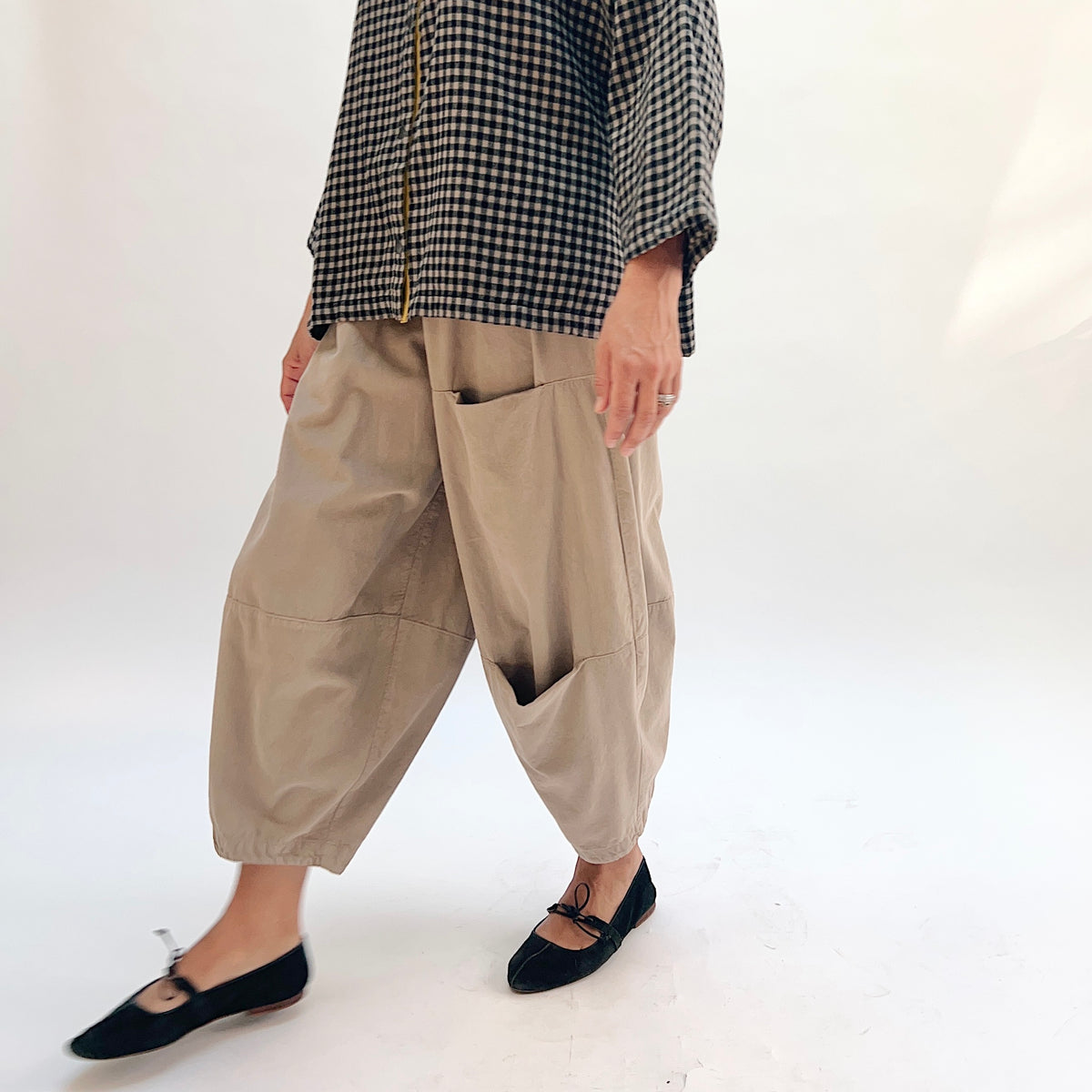 Eleven Stitch Corduroy Three Pocket Pant in Fennel, three-quarter front view showing the balloon leg silhouette, curved thigh pocket, and elasticized ankle cuff in warm sand corduroy
