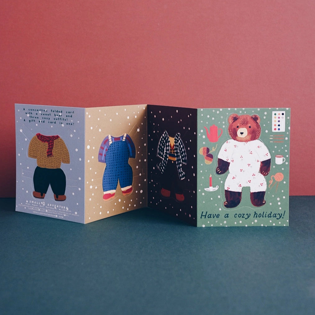Small Adventure Bear Paper Doll Cozy Holiday Card, unfolded concertina view showing three outfit panels and the bear panel.
