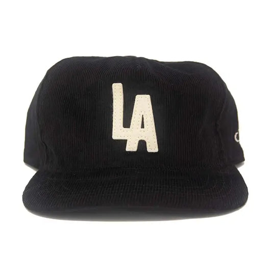 Front view of the LA City Series Snapback in Black Corduroy with cream felt 'LA' appliqué on a white background.