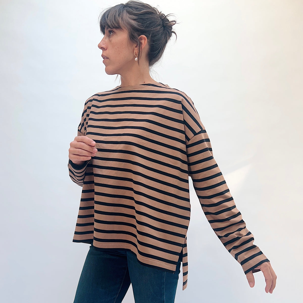 Angled front view of the mocha and navy striped knit pullover, showing the long sleeve and side slit at the hem.
