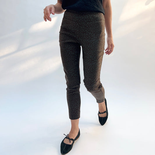 Lisette Sepia Leopard Slim Ankle Pant, front view in motion showing the slim ankle fit and sepia leopard print on a deep ground
