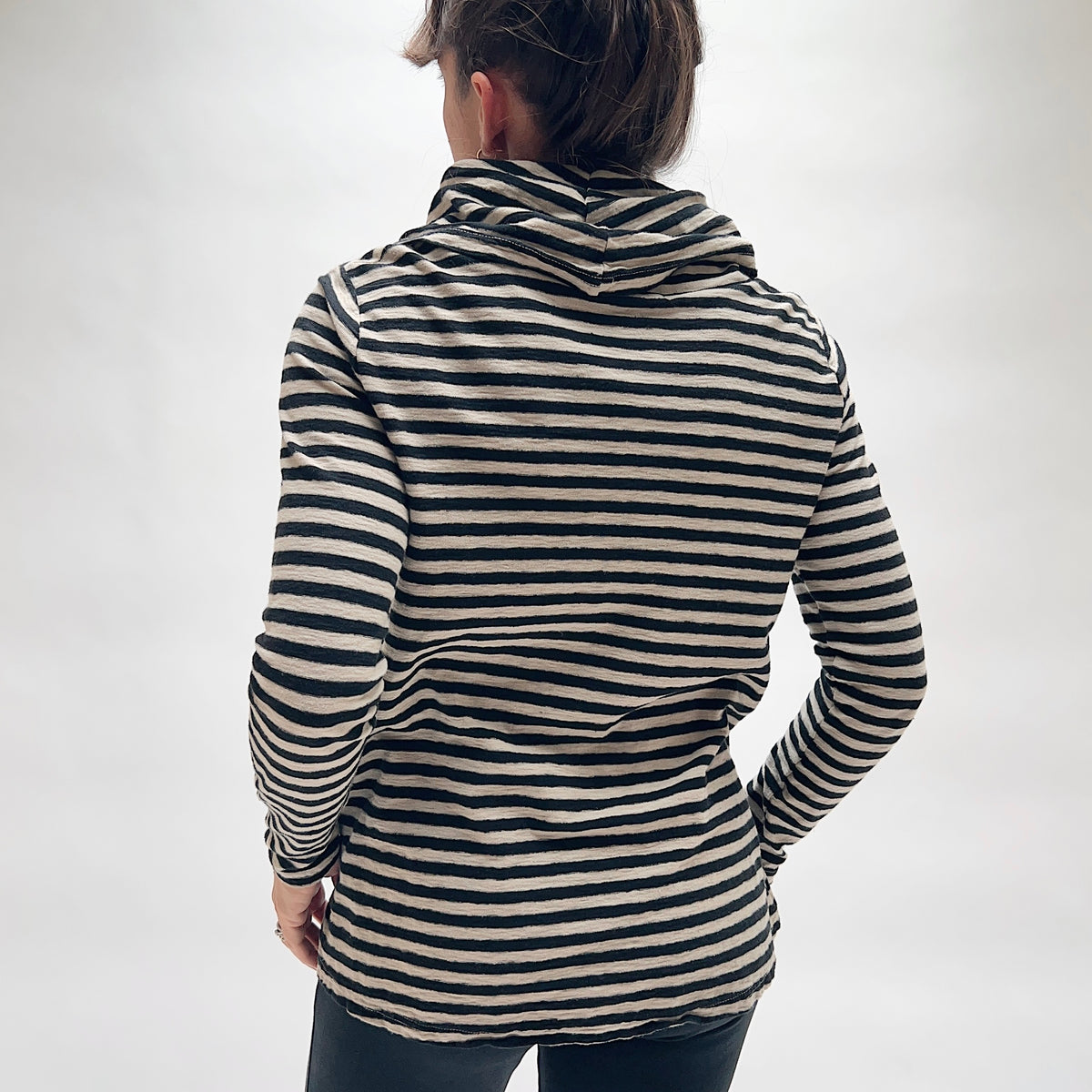 Back view of the Cut Loose Striped Cowl Neck Pullover in Moonbeam, showing the relaxed A-line silhouette, long sleeves, draped cowl neck at the back, and curved hem in moonbeam and black horizontal stripe cotton-linen blend
