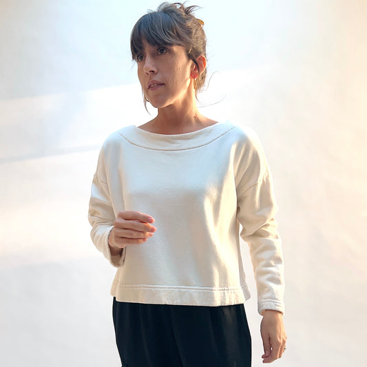 Front view of Bryn Walker Button Back Fleece Pullover in Cream on a model, showing the wide neckline, dropped shoulders, and cropped hem.
