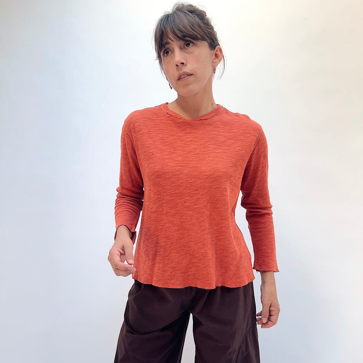 North Star Base Double Cotton Tee in Rusty, front view showing the crew neck with raw-edge finish and slightly cropped sleeves in rusty orange
