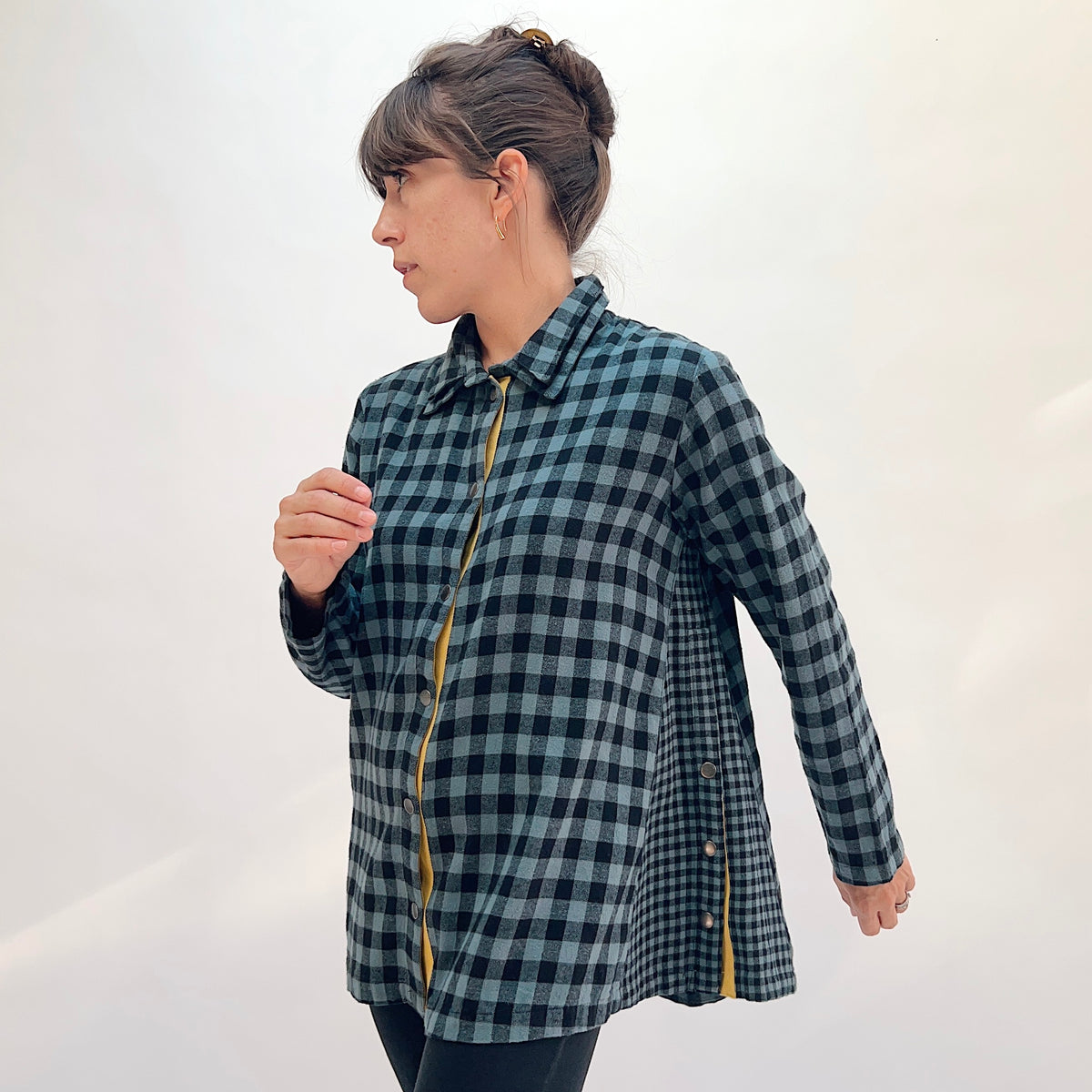Eleven Stitch Placket Gusset Shirt in Dusty Denim, three-quarter front view showing the oversized silhouette in dusty blue and black gingham check with high funnel collar and mustard contrast placket
